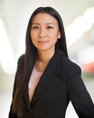 woman executive headshot portrait with office blurred white background