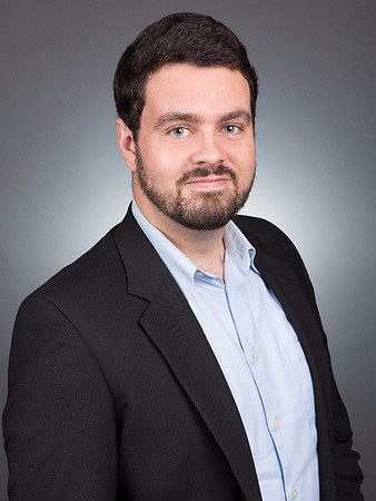 Man with barb and dark jacket for executive corporate headshot in studio with gray background