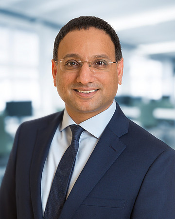 Man with glasses and jacket for Executive Corporate headshot with blurred office background