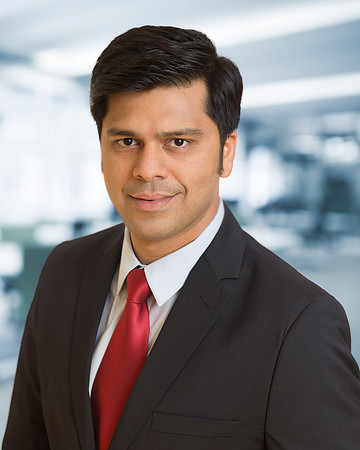 Man with red tie and jacket for Executive Corporate headshot with blurred office background
