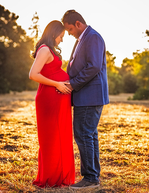 maternity session couple facing each other at sunset