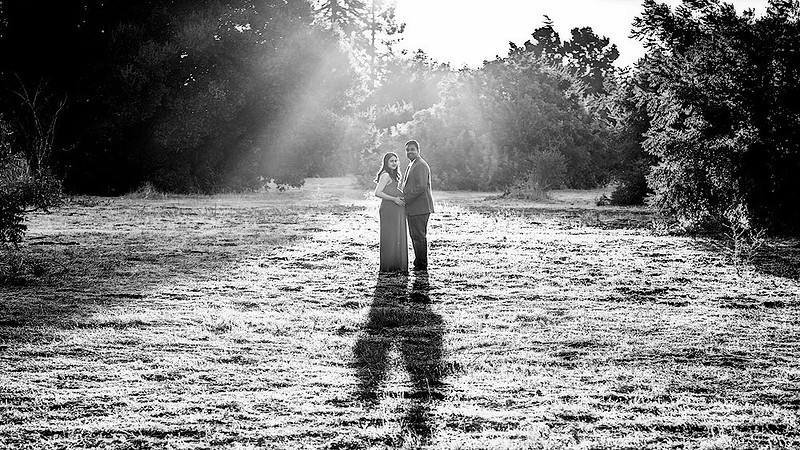 maternity session couple in the middle of big field holding their hands