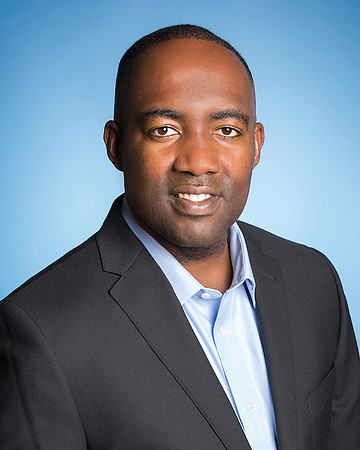 Man Portrait wearing a jacket and blue shirt against blue background