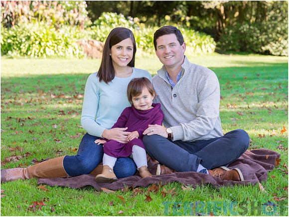 family_of_three_seating_and_posing_in_park