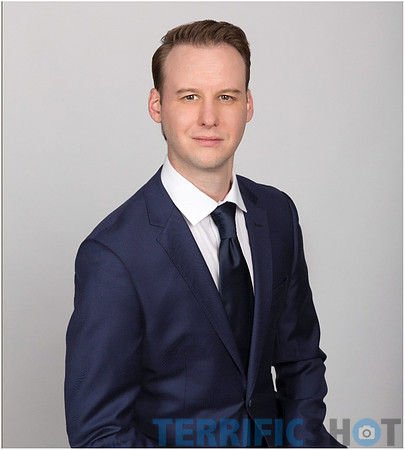 man_with_suit_portrait_studio_gray_background-min