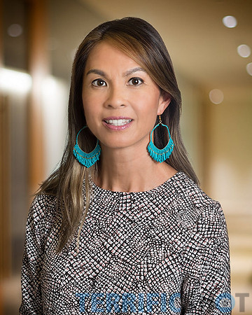 woman_corporate_executive_headshot_with_defocused_blurred_office_background-min